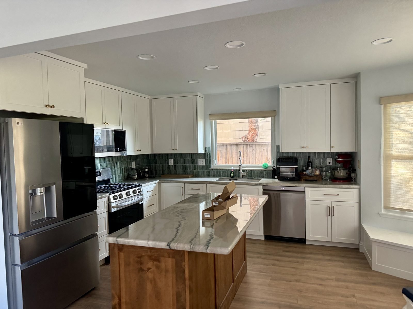 Finished custom kitchen remodel in Reno NV — white shaker cabinets, quartzite island, green glass backsplash
