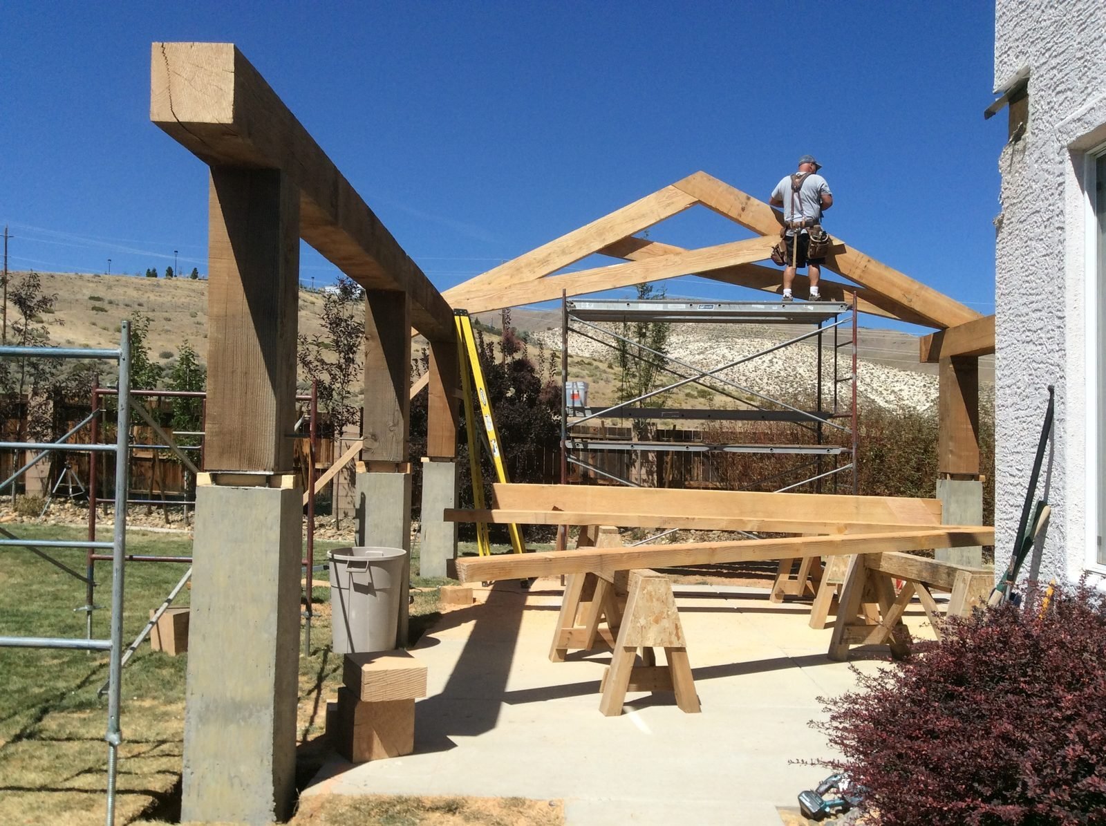 Timber patio cover construction with craftsman on top of ridge Reno NV
